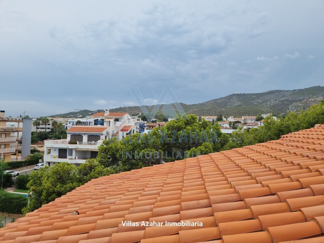Panoramablick mit Bergkulisse: Mediterrane Dachlandschaft mit Weitblick über Küstenort